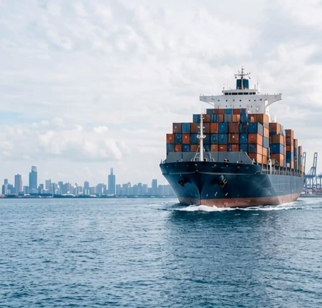 Porte-conteneurs chargé quittant un port, ville en arrière-plan